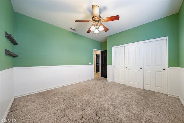 unfurnished bedroom featuring light carpet, a closet, and ceiling fan