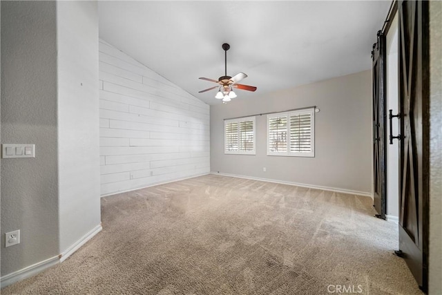 carpeted spare room with ceiling fan and lofted ceiling