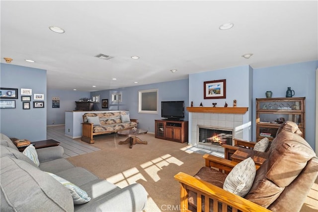 carpeted living room featuring a tile fireplace