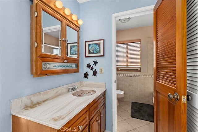 bathroom featuring toilet, tile walls, tile patterned floors, and vanity