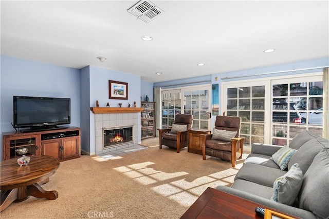 carpeted living room with a tiled fireplace