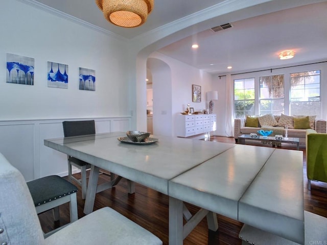 dining area featuring crown molding and dark wood-type flooring