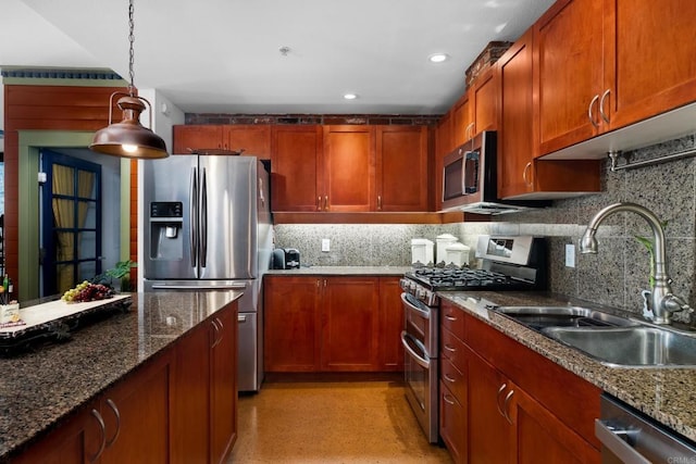 kitchen featuring sink, tasteful backsplash, hanging light fixtures, dark stone countertops, and stainless steel appliances