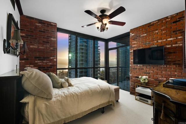 bedroom with access to exterior, a wall of windows, ceiling fan, and carpet flooring