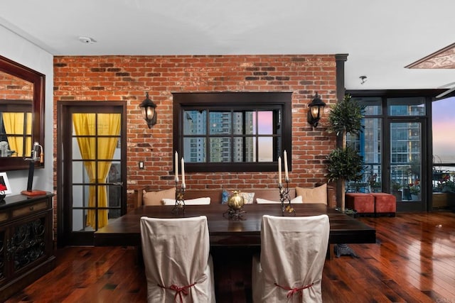 dining area with brick wall, dark hardwood / wood-style floors, and a wall of windows