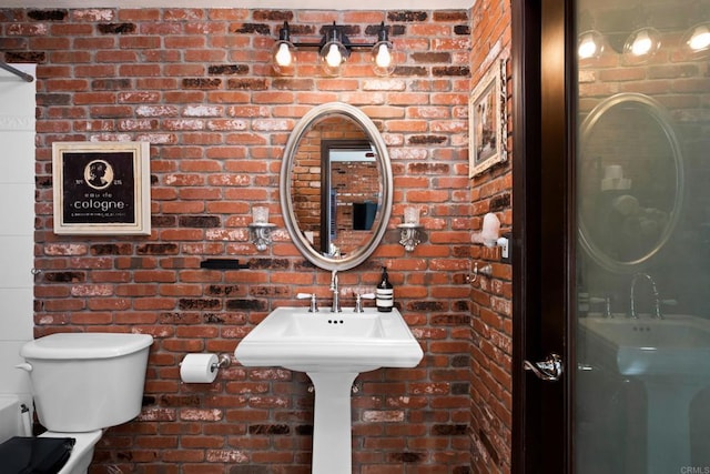 bathroom with brick wall and toilet