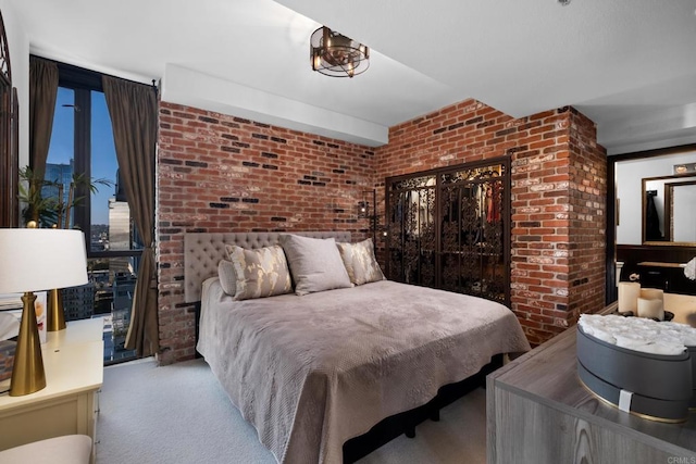 bedroom with brick wall and light colored carpet