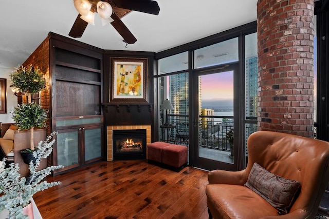 living room with dark wood-type flooring, a wall of windows, and a fireplace