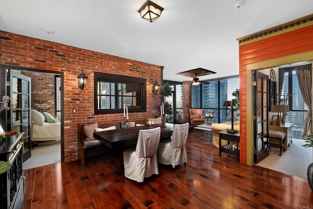 dining area featuring ceiling fan, brick wall, and dark hardwood / wood-style floors