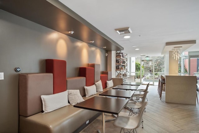 dining space with light parquet floors and a wall of windows