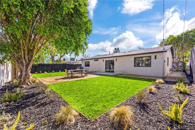 back of property with a lawn and a patio