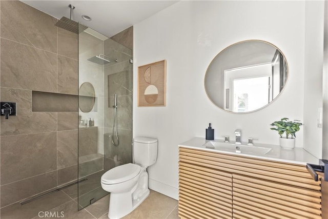 bathroom with tile patterned floors, tiled shower, toilet, and vanity