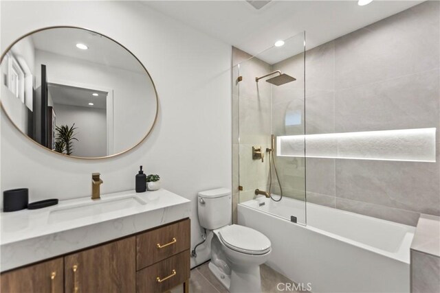 full bathroom featuring toilet, tiled shower / bath, and vanity