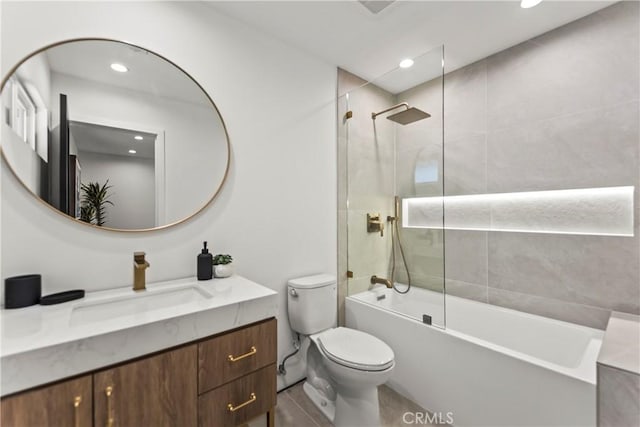 full bathroom with vanity, tiled shower / bath, and toilet