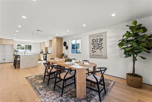 dining area with sink and light wood-type flooring