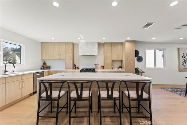 kitchen featuring a wealth of natural light, a center island, sink, and stainless steel dishwasher