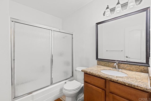 full bathroom featuring enclosed tub / shower combo, toilet, and vanity