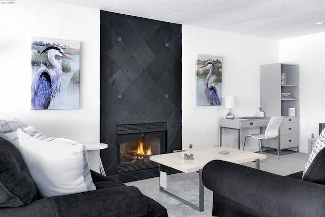 living room with a tile fireplace and a textured ceiling