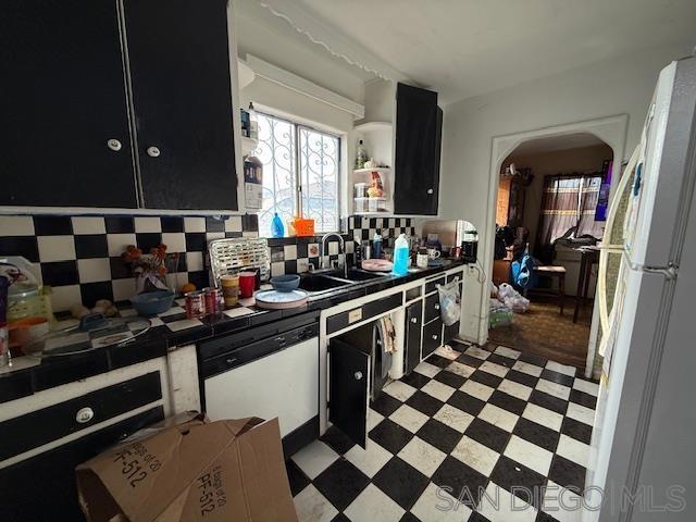 kitchen featuring tasteful backsplash, sink, white appliances, and tile countertops