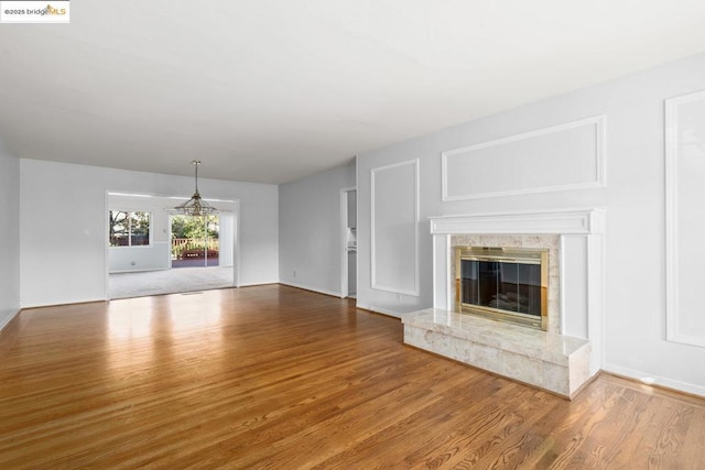 unfurnished living room featuring wood-type flooring and a premium fireplace