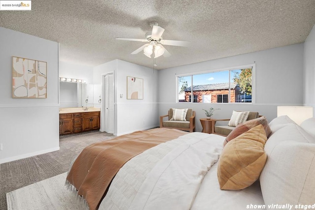 carpeted bedroom with ensuite bathroom, a textured ceiling, ceiling fan, and a closet