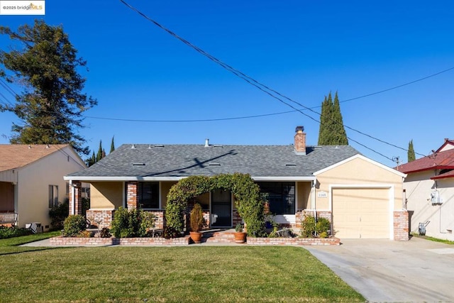 ranch-style home featuring a garage, covered porch, and a front yard