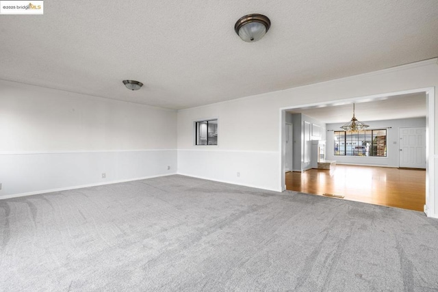 unfurnished living room featuring carpet floors and a textured ceiling