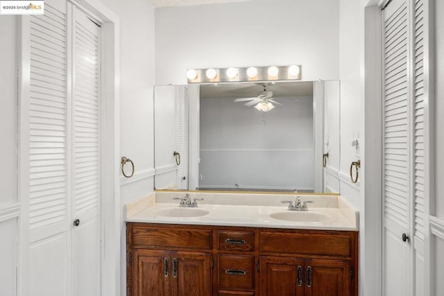 bathroom with ceiling fan, vanity, and a textured ceiling