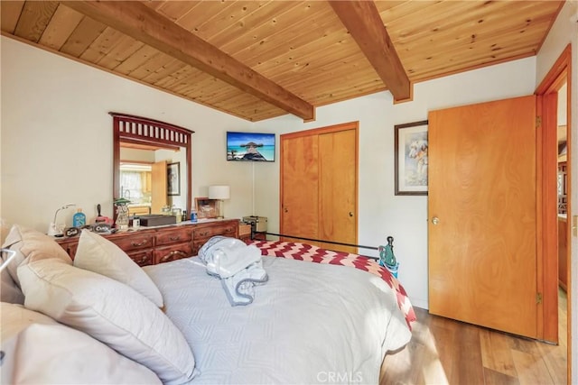 bedroom with wood ceiling, a closet, light hardwood / wood-style flooring, and beamed ceiling