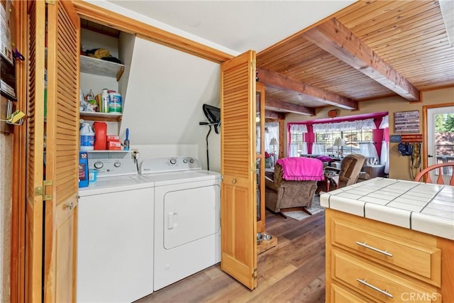 laundry area featuring washer and clothes dryer, wooden ceiling, and light hardwood / wood-style floors