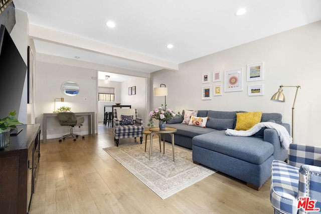 living room with light hardwood / wood-style floors and beamed ceiling