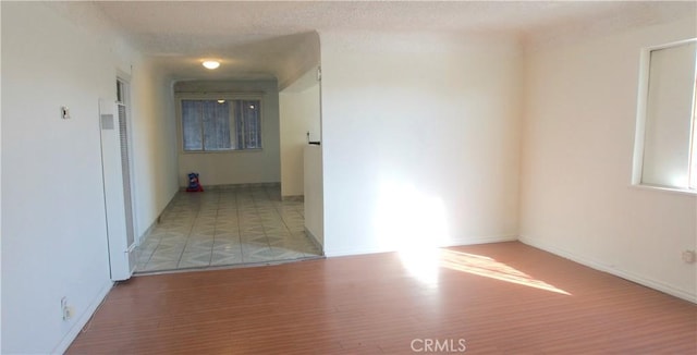 hallway featuring a textured ceiling and light hardwood / wood-style flooring