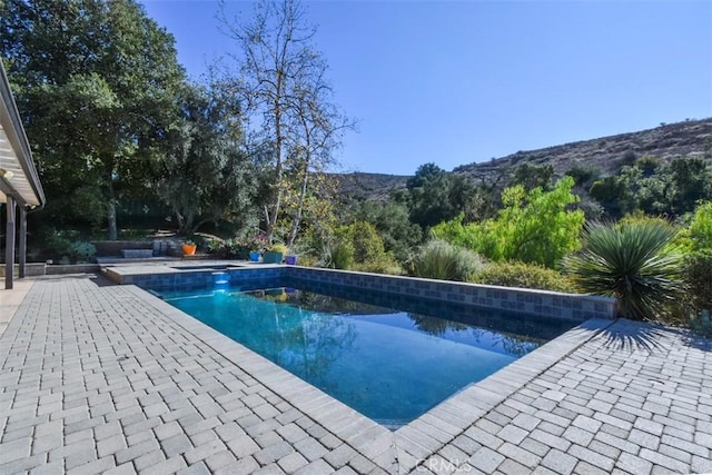 view of swimming pool with a patio area and a mountain view