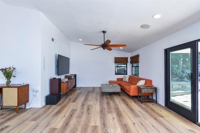 living room with ceiling fan, light hardwood / wood-style flooring, and lofted ceiling