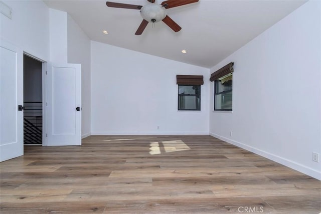 empty room with ceiling fan, light hardwood / wood-style floors, and lofted ceiling