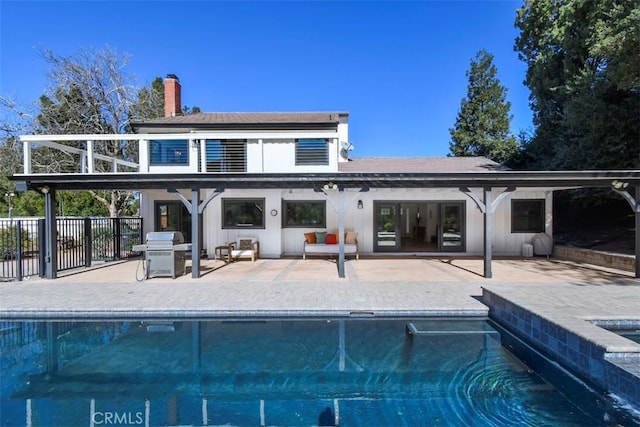 back of house with a fenced in pool and a patio