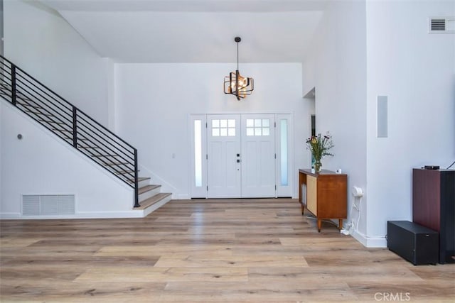 entryway featuring light wood-type flooring and an inviting chandelier