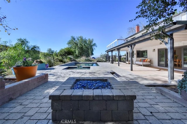 view of pool featuring a patio and a fire pit