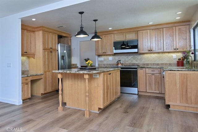 kitchen with light stone counters, hardwood / wood-style flooring, a center island, and stainless steel appliances