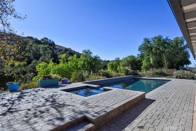 view of swimming pool with an in ground hot tub