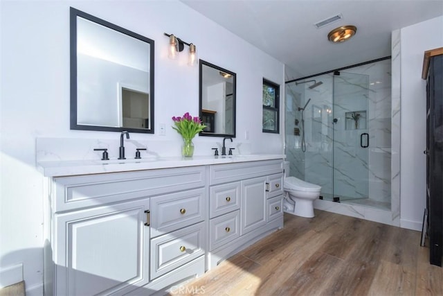 bathroom with vanity, walk in shower, hardwood / wood-style floors, and toilet