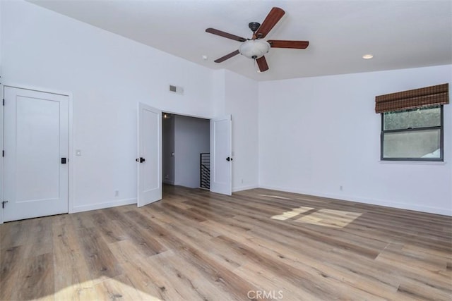 unfurnished bedroom featuring ceiling fan, vaulted ceiling, and light hardwood / wood-style floors