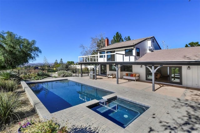 back of property featuring a patio area and a swimming pool with hot tub