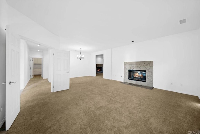 unfurnished living room with a fireplace, light colored carpet, and a notable chandelier