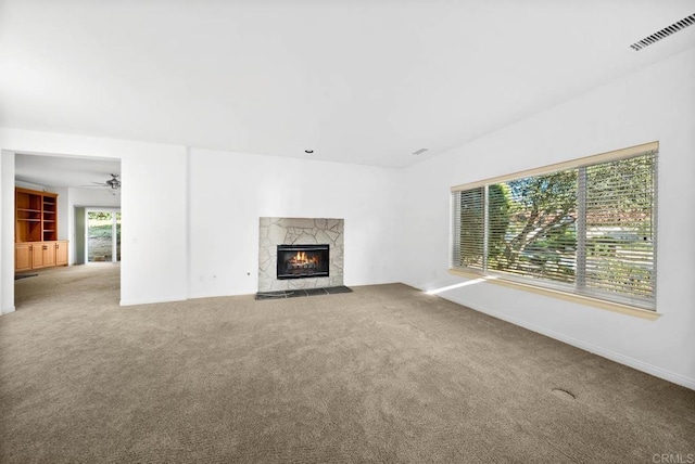 unfurnished living room featuring a fireplace, carpet flooring, and ceiling fan