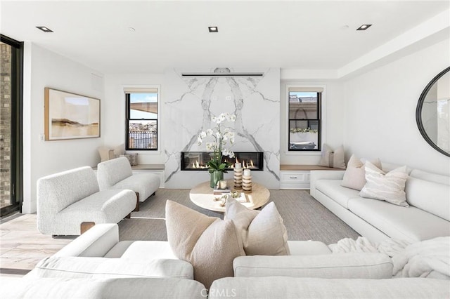 living room featuring a high end fireplace and light hardwood / wood-style flooring