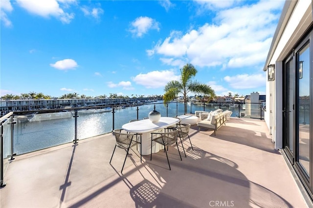 view of patio / terrace with a balcony and a water view