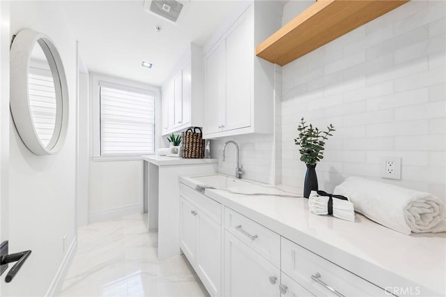 laundry room featuring sink and cabinets