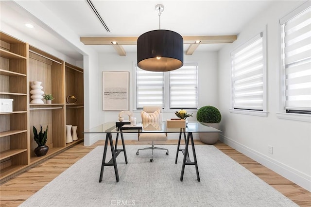 home office featuring light hardwood / wood-style floors and beam ceiling