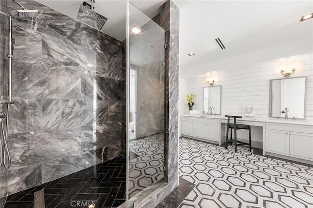 bathroom with vanity and a tile shower